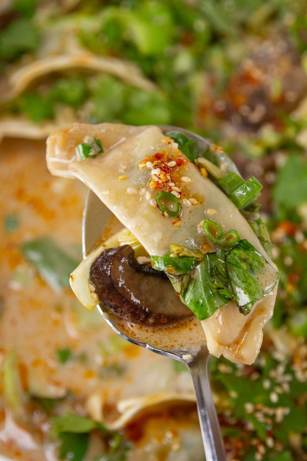 serving a dumpling from the casserole dish.