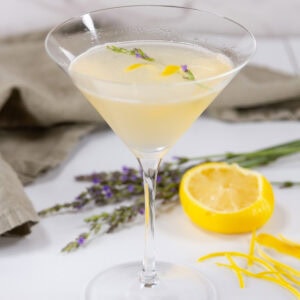 square crop of a lemon drop martini with a green napkin and lemon wedge in the background.