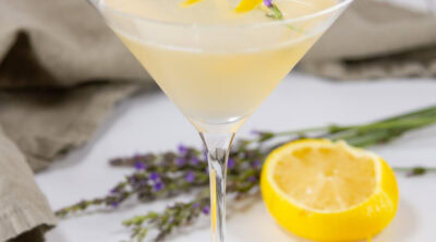 square crop of a lemon drop martini with a green napkin and lemon wedge in the background.