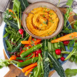 square crop of a bowl of hummus on a veggie platter.