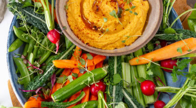 square crop of a bowl of hummus on a veggie platter.