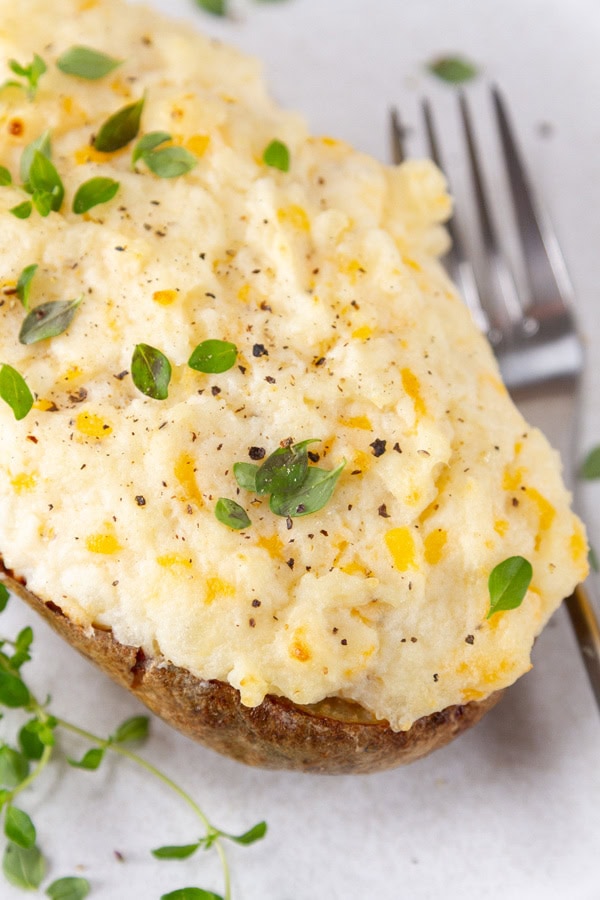a baked potato topped with cheesy mashed potatoes.