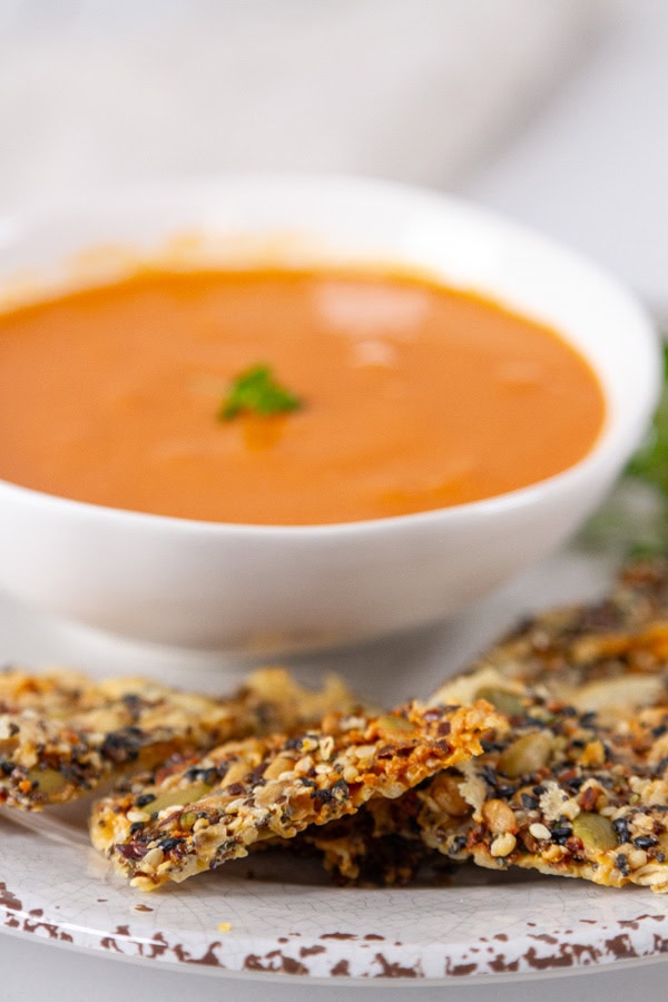 crackers next to a bowl of soup.