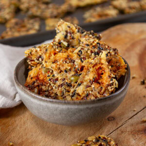 square crop of a bowl with seed crackers inside.