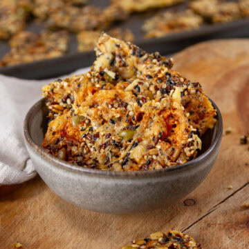 square crop of a bowl with seed crackers inside.