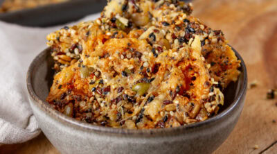 square crop of a bowl with seed crackers inside.