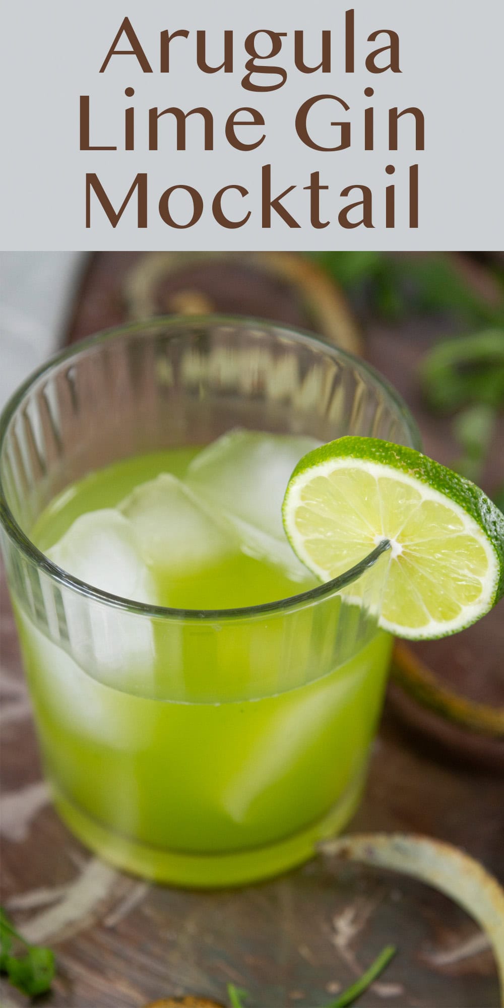 a glass filled with green drink and garnished with a lime.