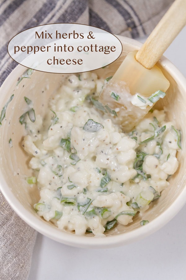 herbed cottage cheese in a bowl with a spatula.