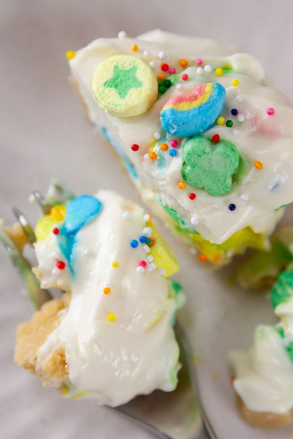 a cheesecake cut in half and a bite is on the fork next to it.