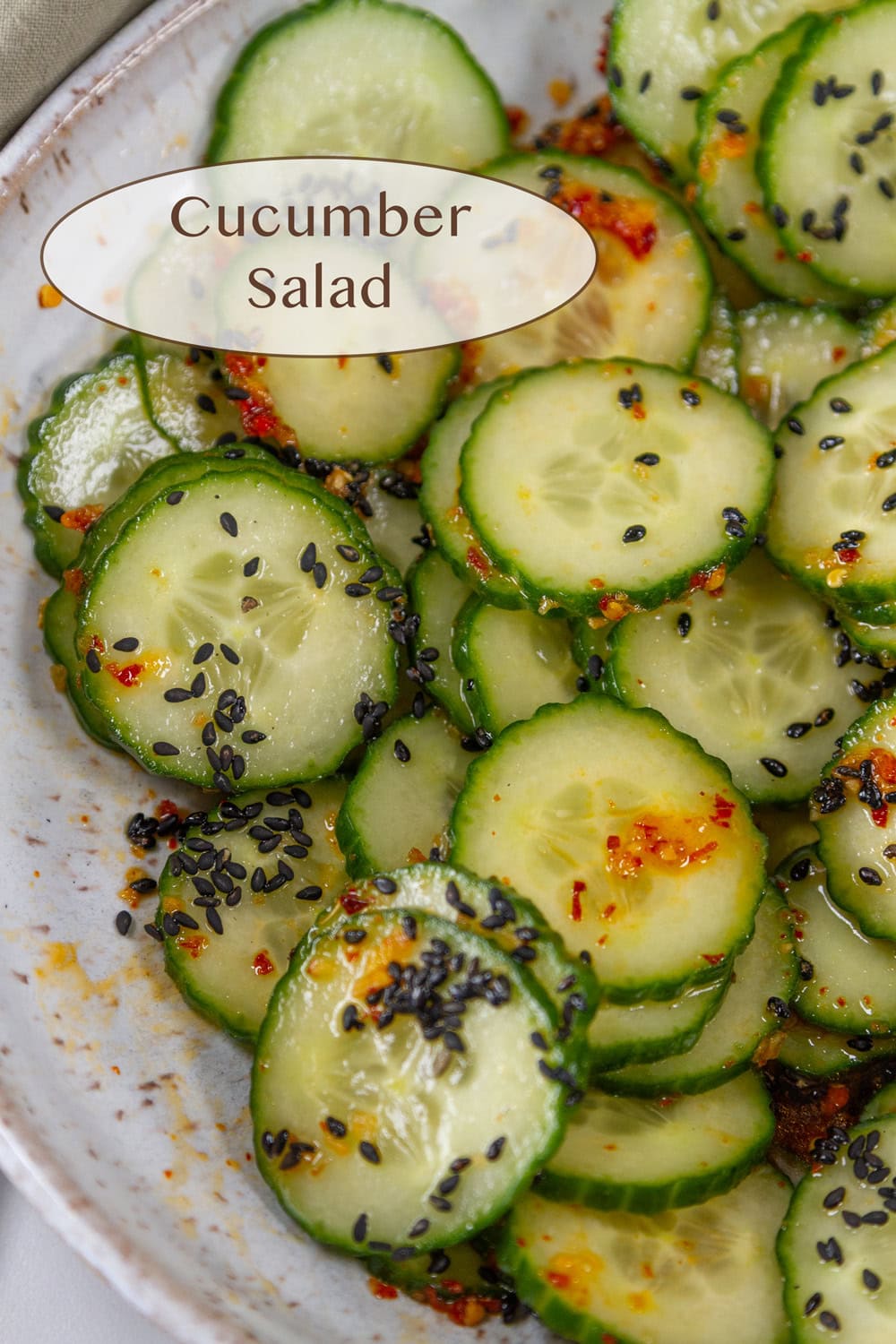 a white bowl with spicy cucumber salad in it.