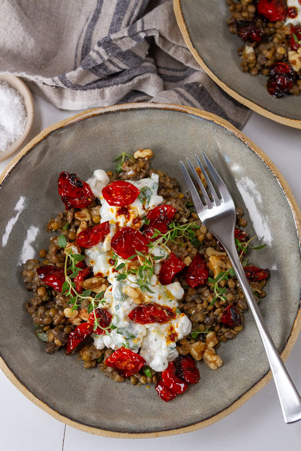 two bowls of protein filled lentils one bowl has a fork in it.