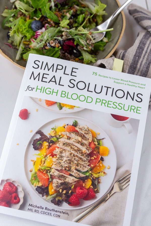 The book, Simple Meal Solutions for High Blood Pressure, next to a salad.