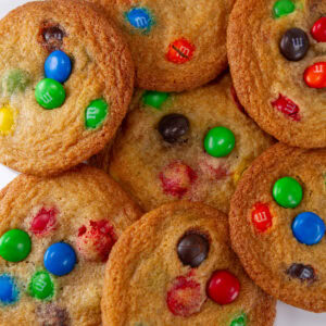 square crop of cookies piled up on a white plate.