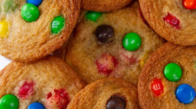 square crop of cookies piled up on a white plate.