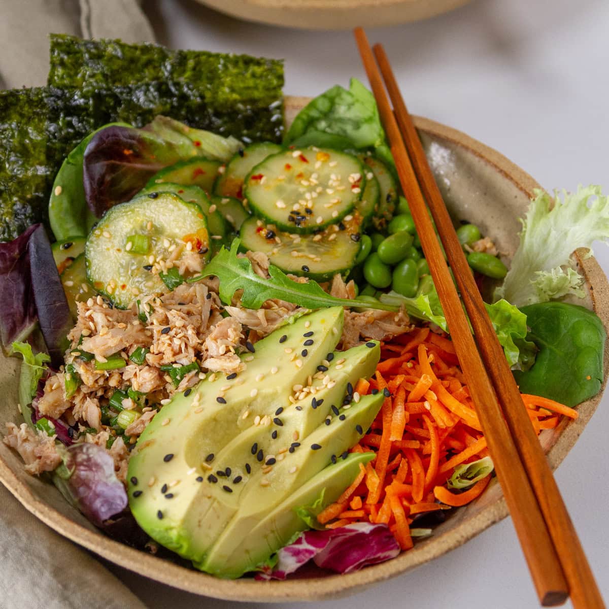 square crop of a healthy Asian tuna bowl with chopsticks on the right.