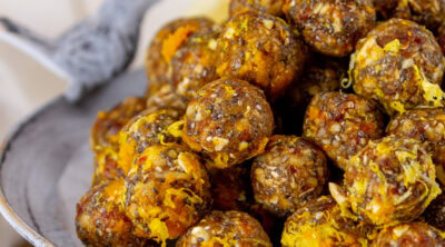 square crop of lemon ginger energy bites on a metal serving tray.