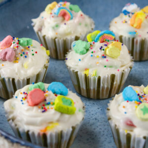 square crop of several individual cheesecakes on a blue serving platter.