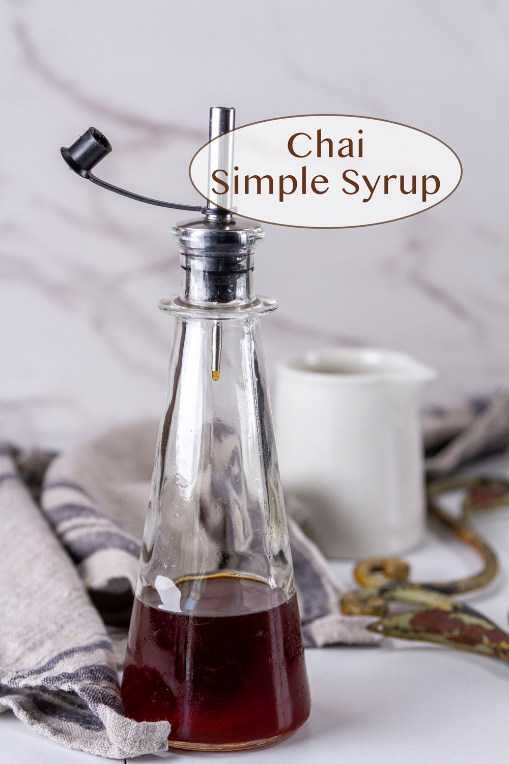 a bottle of chai simple syrup in front of a small jar.