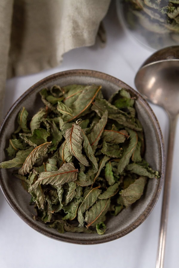looking down into a bowl of dried mint leaves.