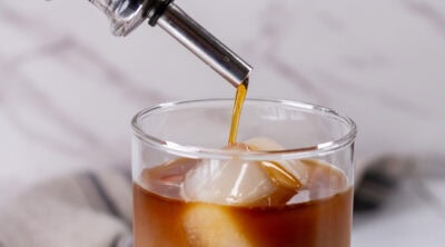 square crop of pouring simple syrup into a glass.