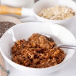 square crop of a bowl of chocolate chia oats with a spoon in it.