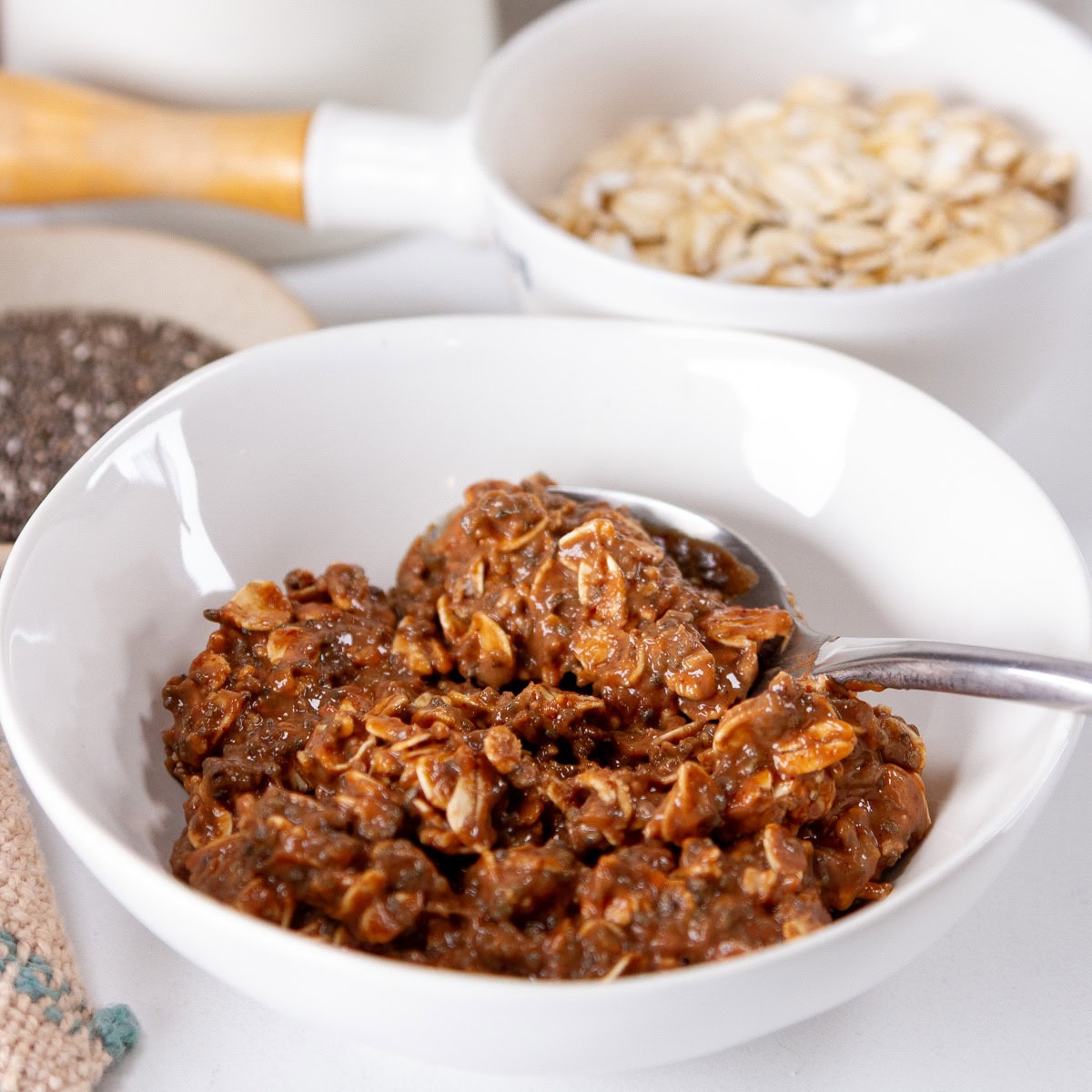 square crop of a bowl of chocolate chia oats with a spoon in it.
