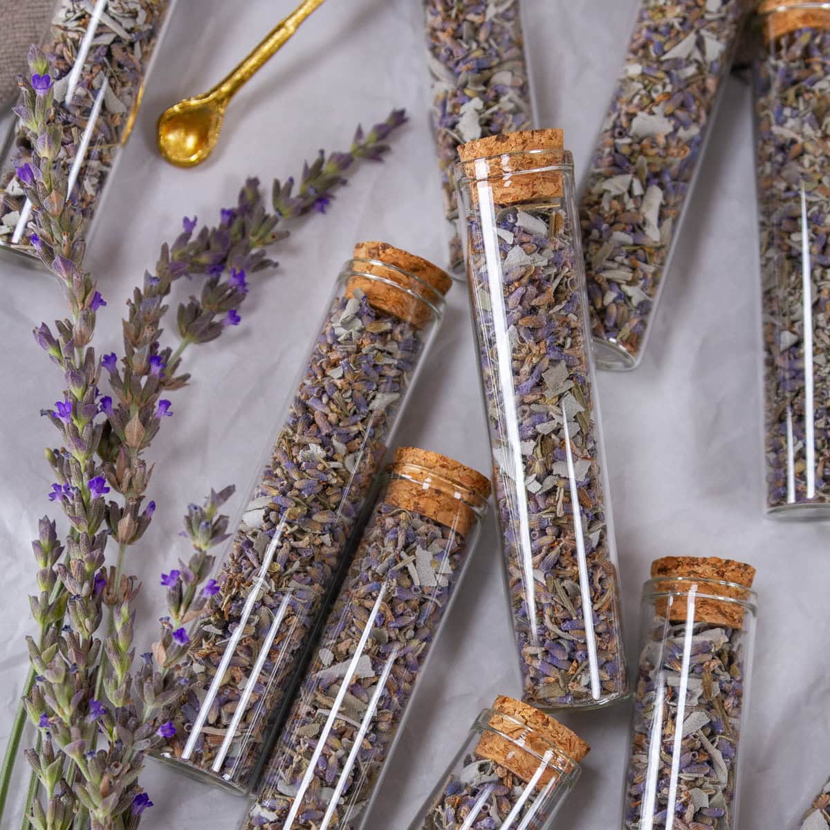 square crop of small glass jars filled with dried lavender sage tea blend.