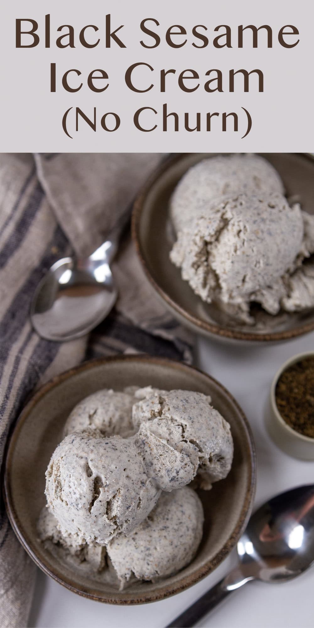 looking down on two small bowls of ice cream with spoons next to them and a blue grey cloth near.