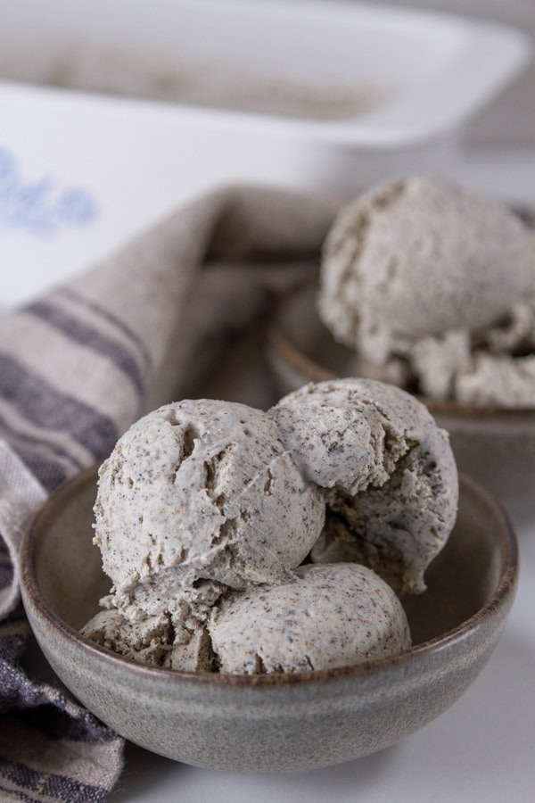 two bowls of ice cream in front of the loaf pan and a towel.
