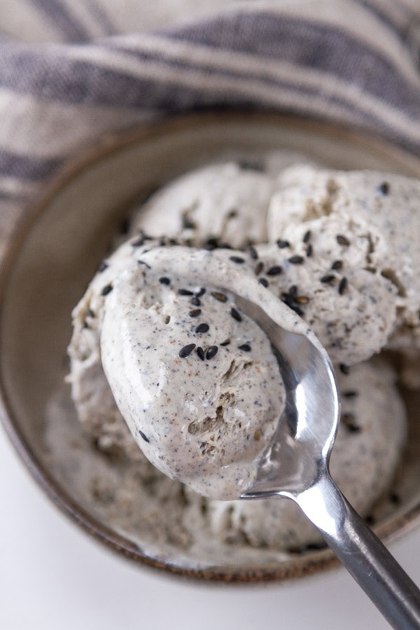 a spoonful of ice cream being raised from the bowl.