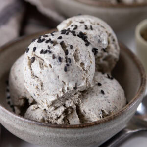 square crop of a bowl of ice cream garnished with sesame seeds.