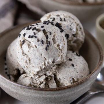 square crop of a bowl of ice cream garnished with sesame seeds.