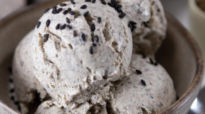 square crop of a bowl of ice cream garnished with sesame seeds.
