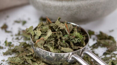 square crop of a measuring spoon filled with dried crushed mint.
