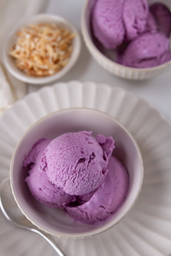 two bowls of ice cream and a small dish of toasted coconut.