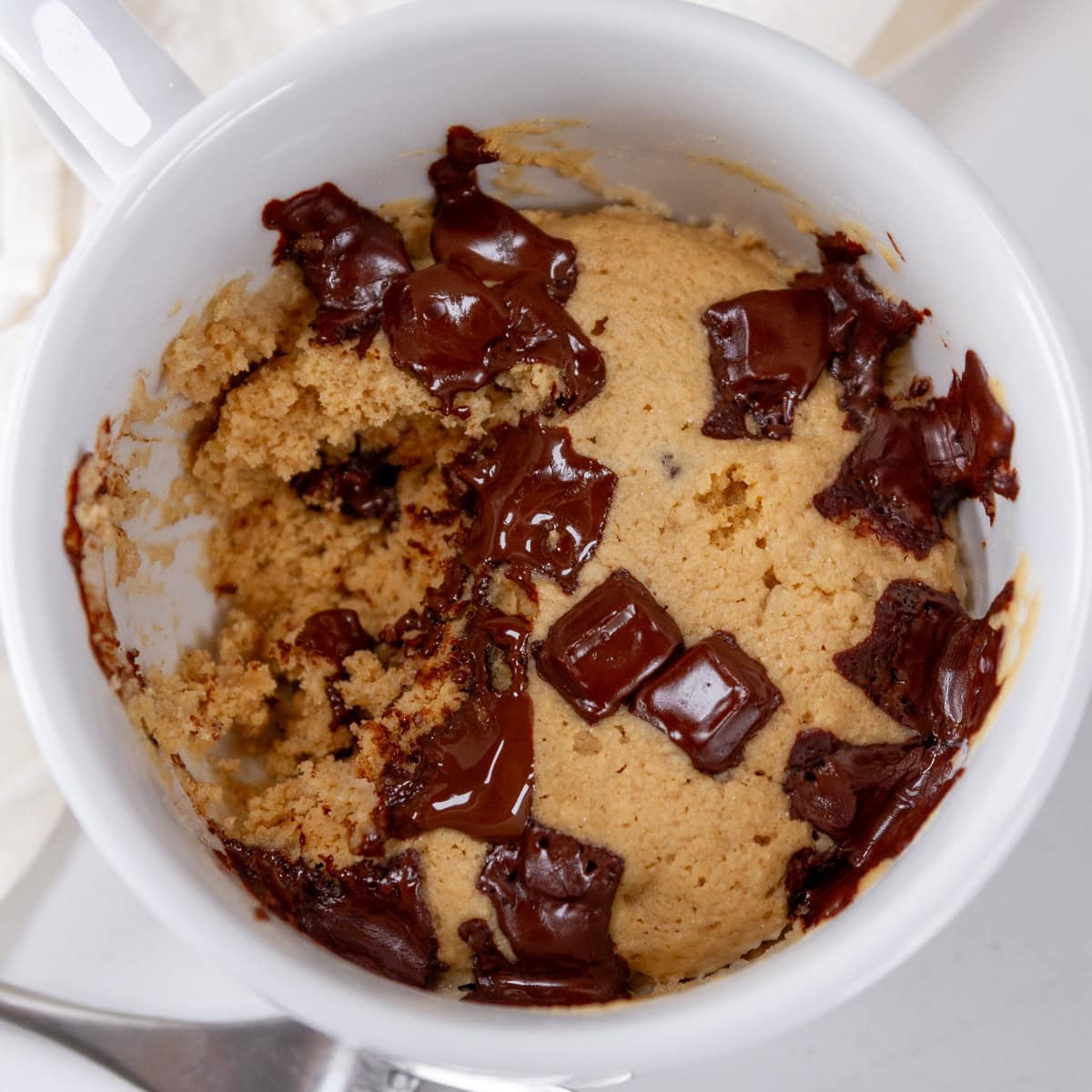 square crop of a mug cake with a bite taken out of it.