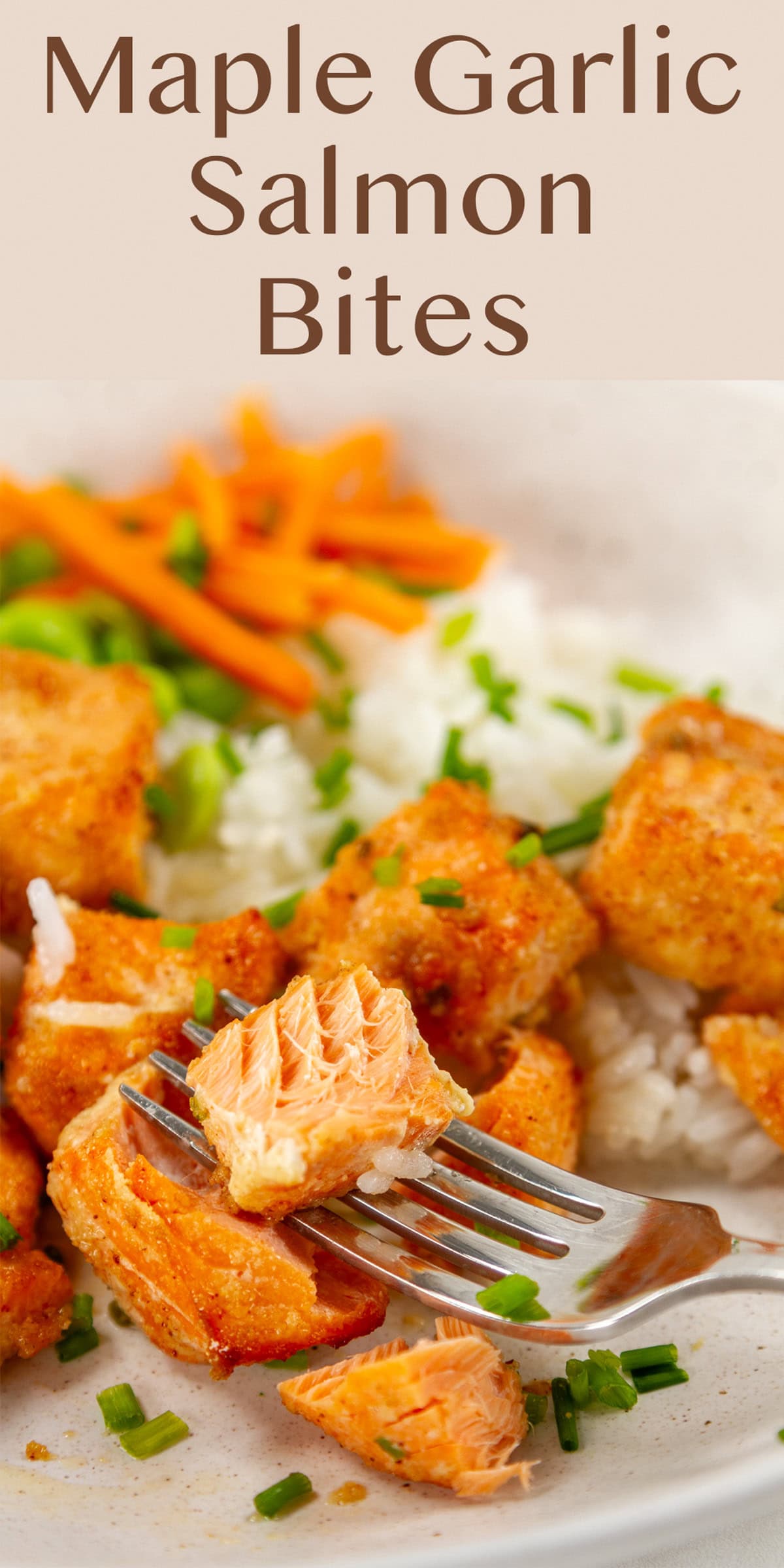salmon cut into cubes and cooked served on rice with veggies and a fork with a bite on it.