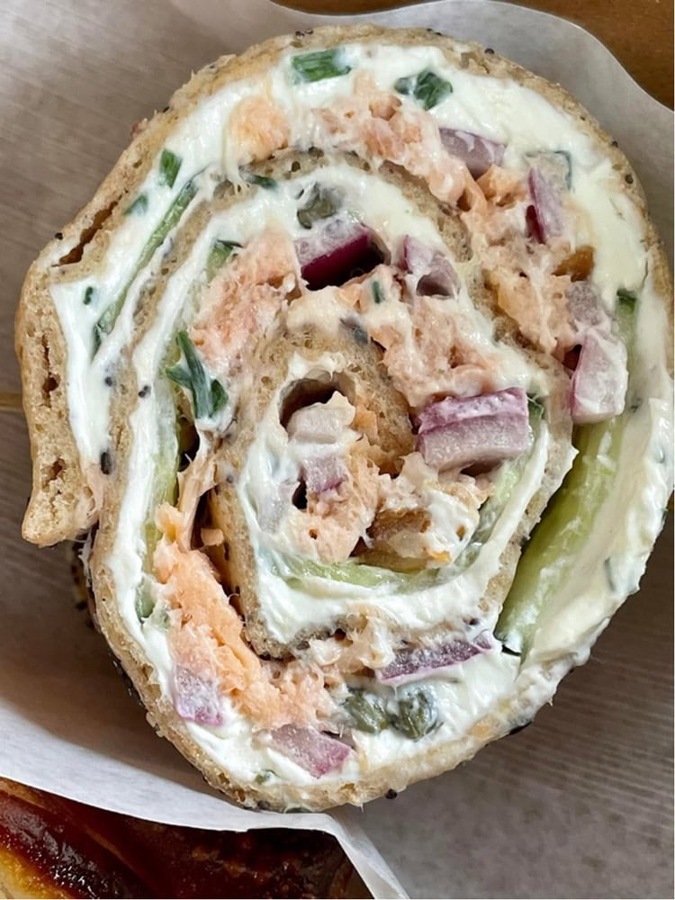 close up on a lavosh wrapped around cream cheese, herbs, and smoked salmon.