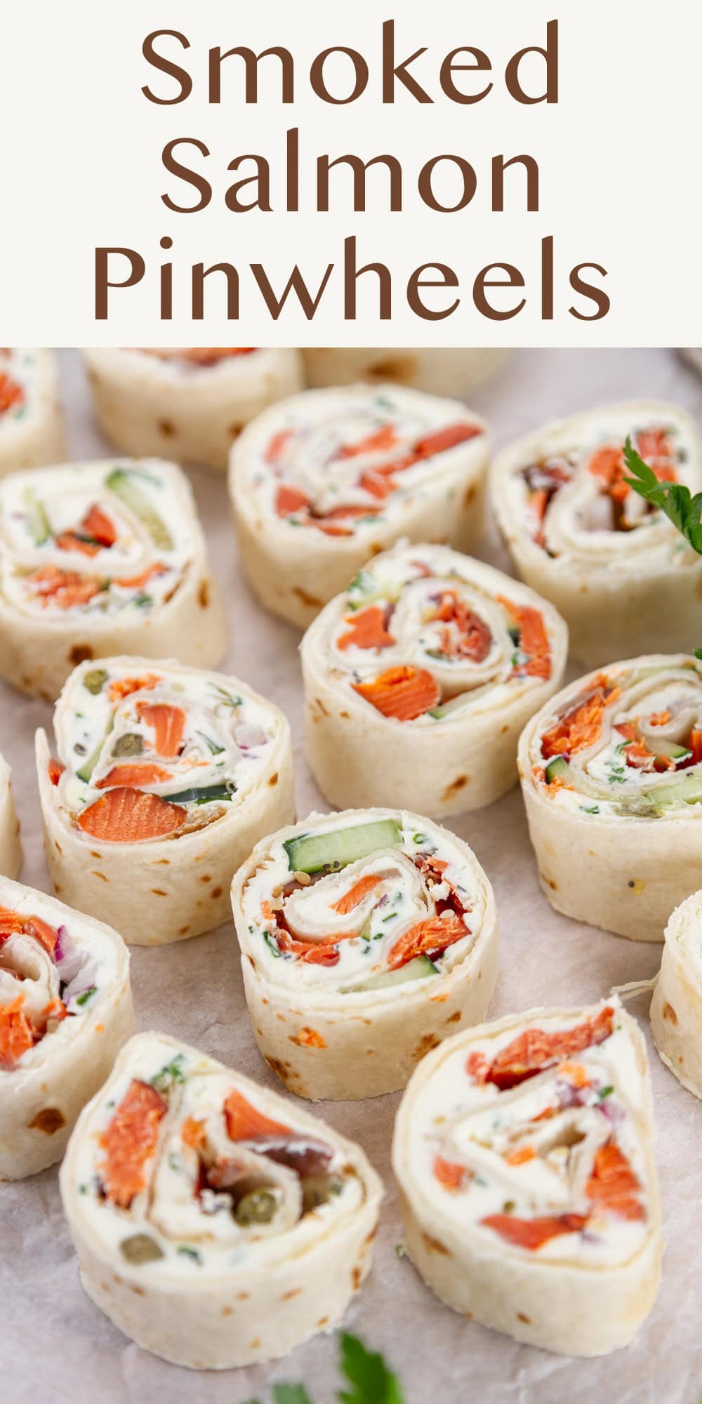pinwheel appetizers with cream cheese and salmon inside on a piece of parchment paper.