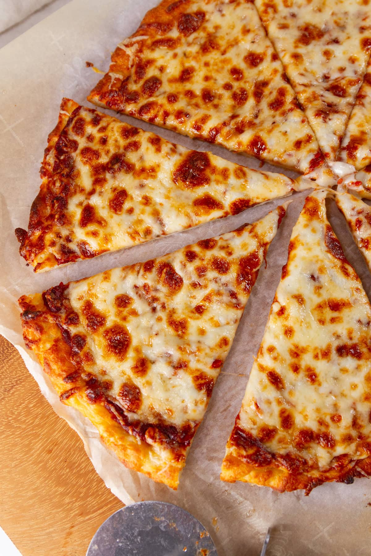 a slice of cheese pizza being taken out of the rest of the pizza.