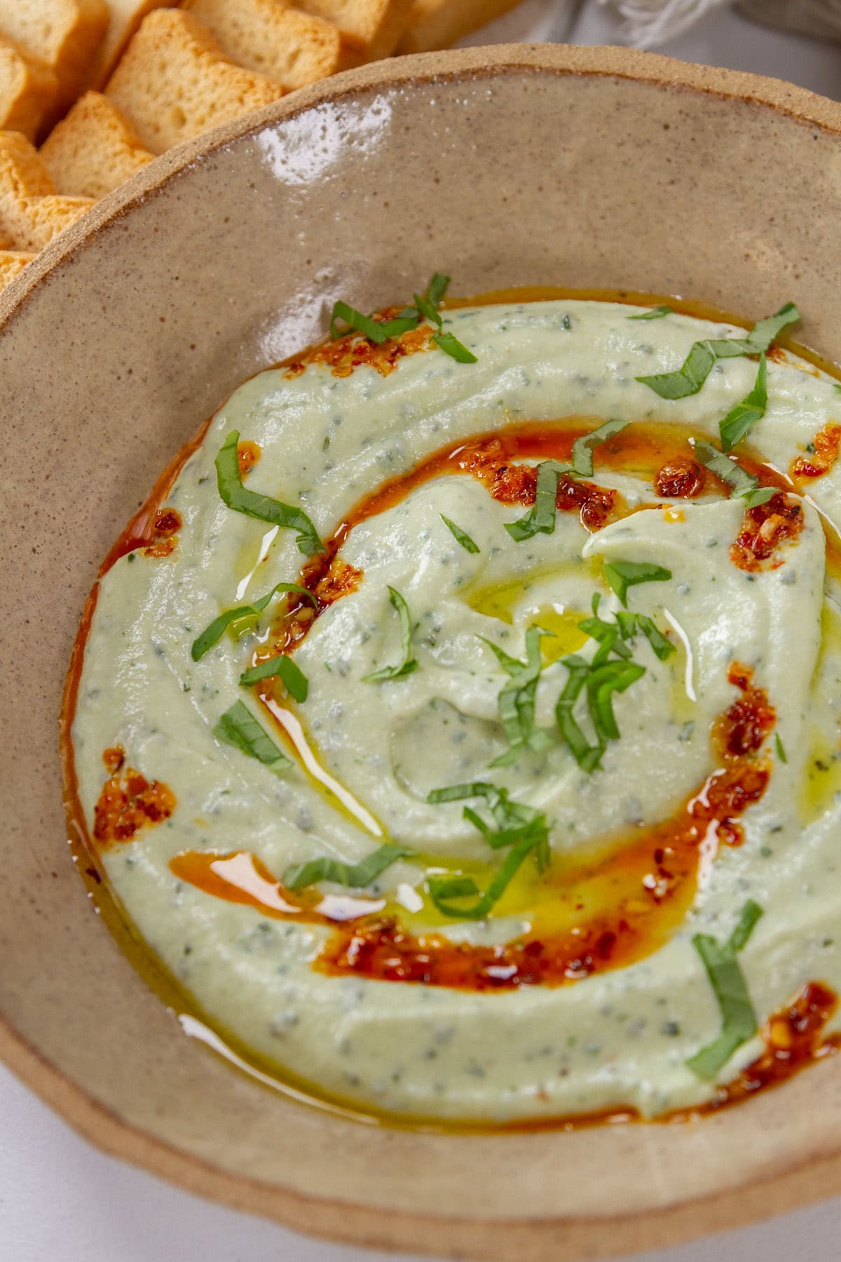 whipped basil ricotta dip in a brown bowl.