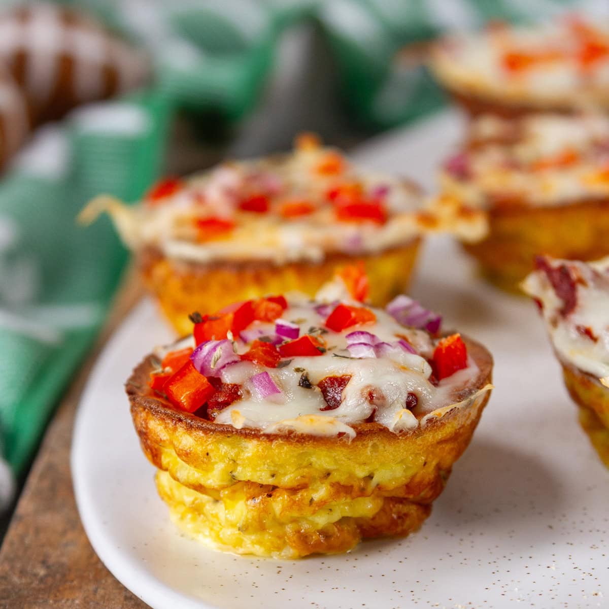 square crop of pizza puffs on a white tray in front of football props.