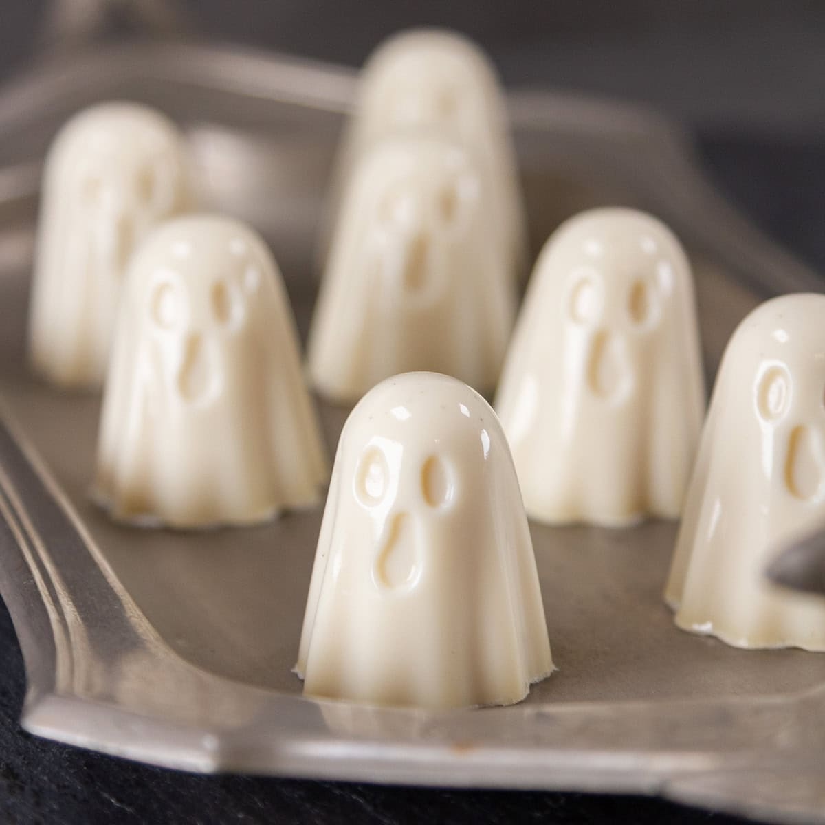 square crop of gelatin ghosts on a pewter tray.