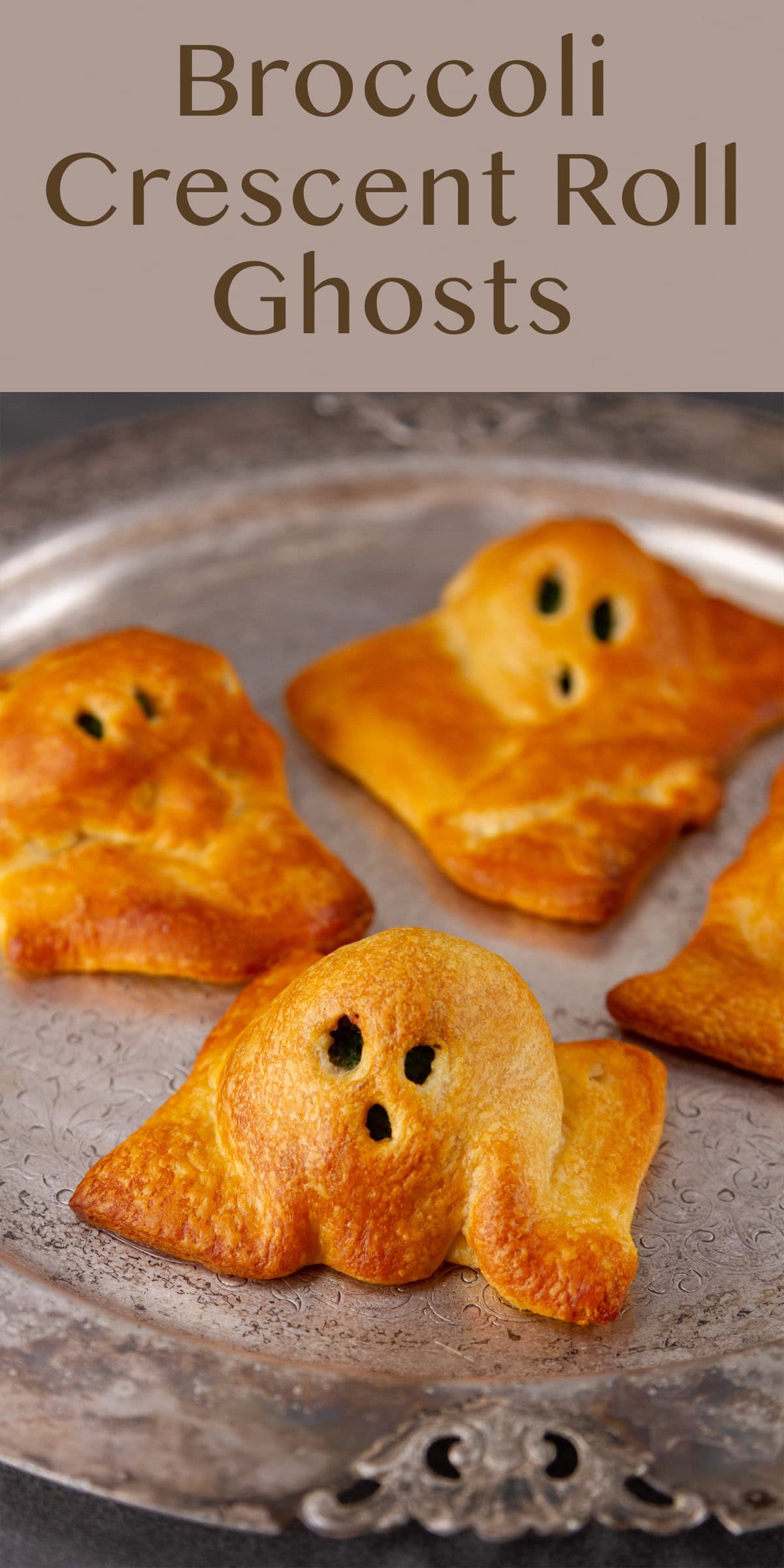 crescent dough shaped like ghosts on a pewter platter.