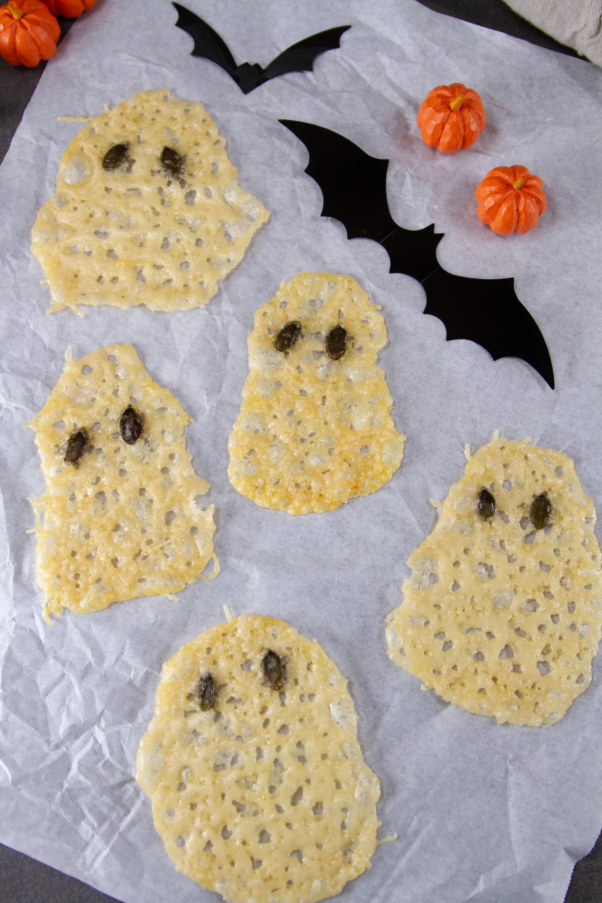 ghost cheese crisps on parchment paper.