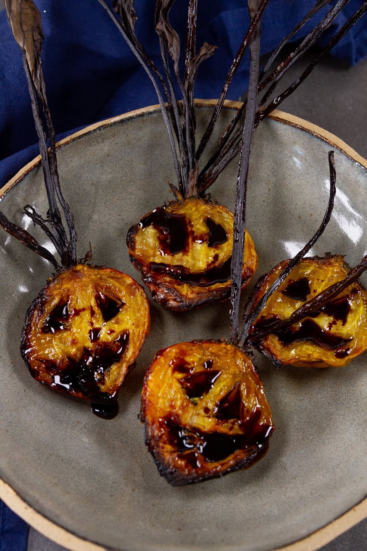 roasted beets in a dark grey bowl with Halloween faces.