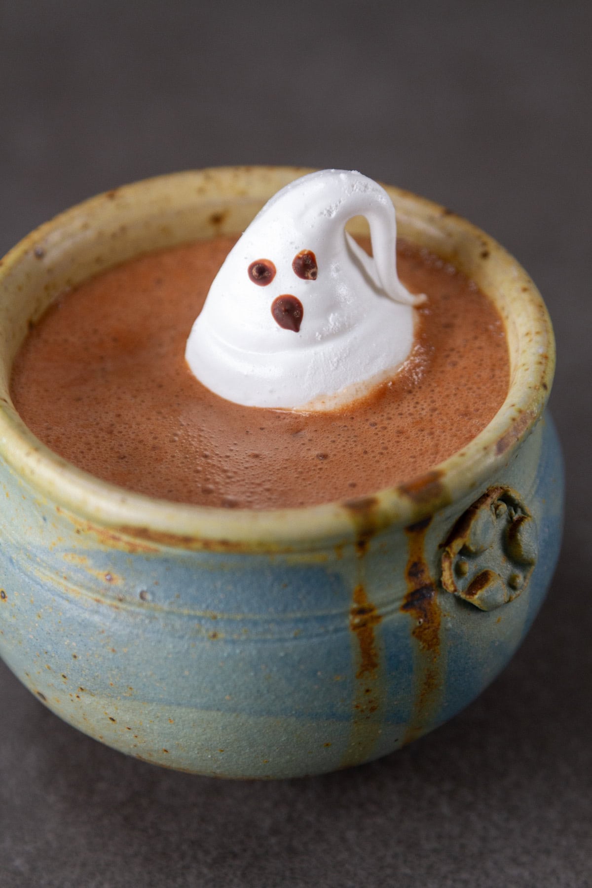 a marshmallow ghost in a mug of hot cocoa.